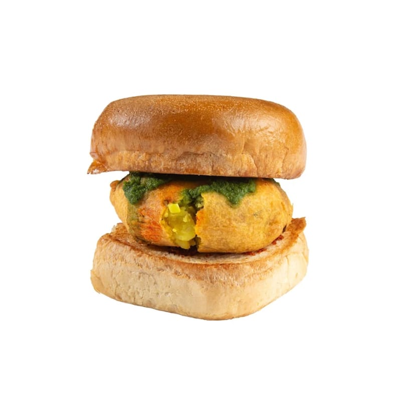 Vada Pav, an Indian street food burger, with a fried potato patty and green chutney on a bun.