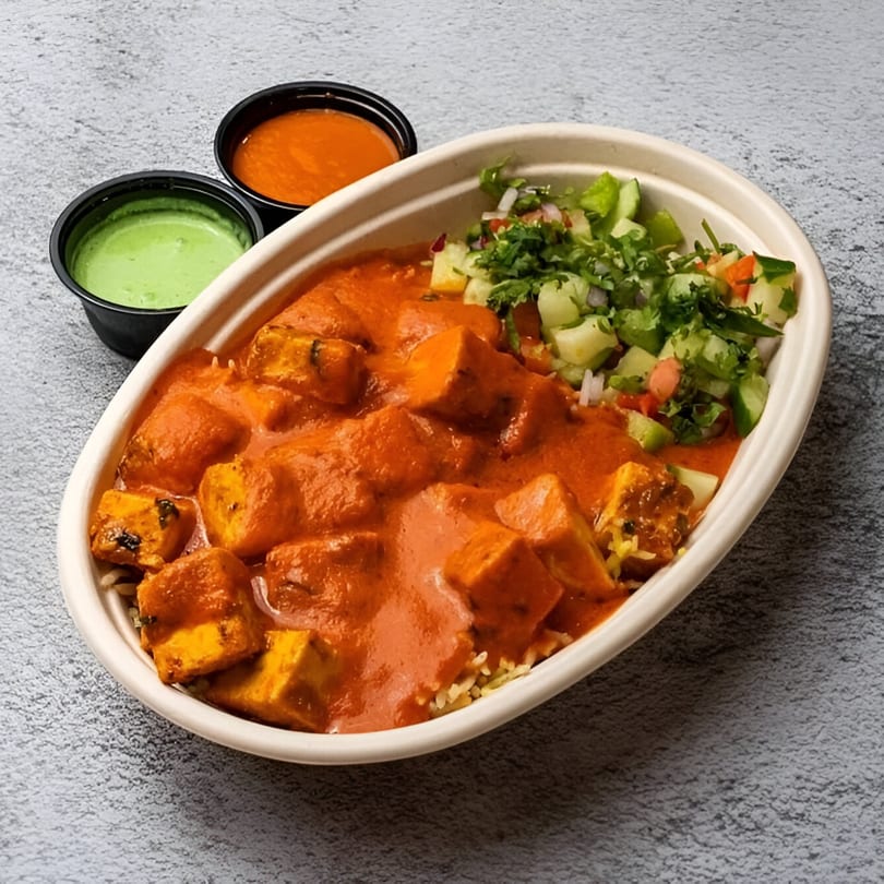 Tandoori Twist Indian Grub's paneer tikka masala bowl with rice, salad, and two sauces.